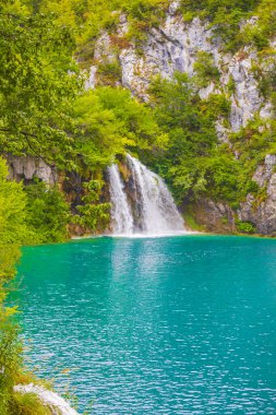Plitvice Lakes Ulusal Parkı şelalesi Hırvatistan 'da turkuaz mavi ve yeşil sularla çevrili.