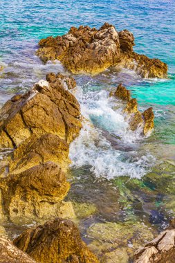 Novi Vinodolski Hırvatistan 'da muhteşem turkuaz ve kayalık plaj ve gezinti güvertesi.