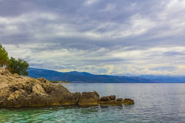 Novi Vinodolski Hırvatistan 'da muhteşem turkuaz ve kayalık plaj ve gezinti güvertesi.