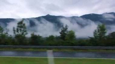 Avusturya 'nın bulutlu dağ manzarasından arabayla geçerken..