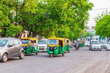 Life and big traffic with Tuk Tuks buses and people in New-Delhi Delhi India. clipart