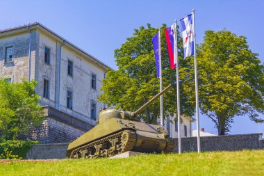 Slovenya 'daki Postojna Pivka Askeri Tarih Parkının Tank ve Bayrakları.