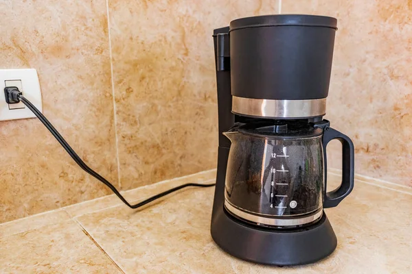 Black coffee maker from Mexico on cream background in clean kitchen.