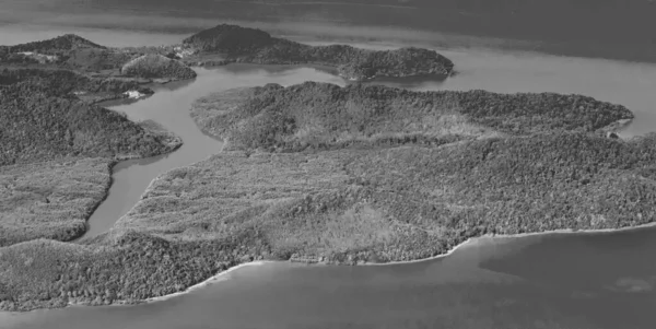 Black and white picture of the flying over Thailand panoramic view of the beautiful islands coastal beaches and clouds.