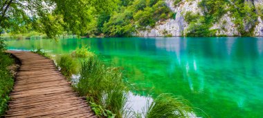 Turkuaz su üzerinde yaya köprüsü olan bir manzara. Hırvatistan 'da Plitvice Lakes Ulusal Parkı.