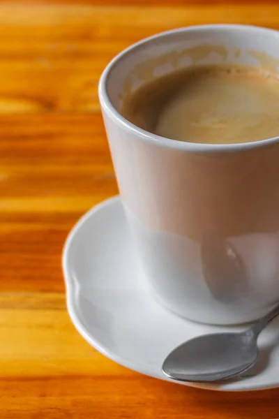 Schwarze Kaffeesahne Einer Weißen Tasse Mit Löffel Auf Einem Holztisch — Stockfoto