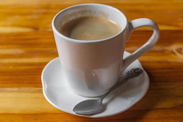 Schwarze Kaffeesahne Einer Weißen Tasse Mit Löffel Auf Einem Holztisch — Stockfoto