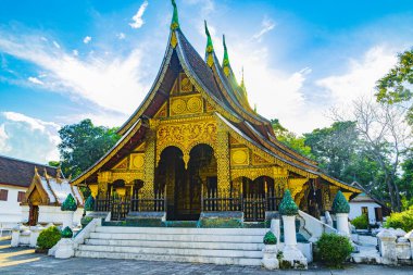 Wat Xieng tangasının arkasındaki güneş ışınları ve güneş ışığı Luang Prabang Laos 'taki en iyi tapınakların altın şehrinin Budist tapınağı..
