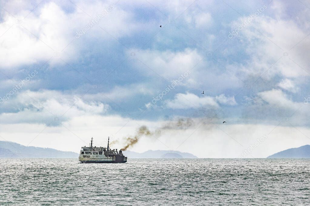 Old dirty ship with black smoke exhaust fumes in the sea near Don Sak Surat Thani Thailand.