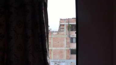 Camdan dışarı bak. Kirli, tozlu inşaat binaları Katmandu Nepal.