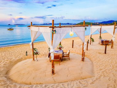 Tailand 'da Koh Samui' de Koh Phangan manzaralı Bo Phut plajında özel romantik bir akşam yemeği..