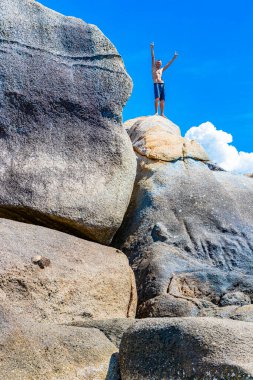 Rus turist tırmanıyor ve Tayland 'da Koh Samui' deki Silver Beach 'te büyük bir kayanın üstünde kendini kutluyor..