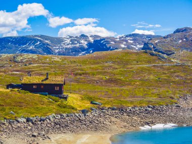 Muhteşem Vavatn Gölü manzarası engebeli kır evleri ve yaz boyunca Norveç 'in Hemsedal bölgesinde karlı dağlar.