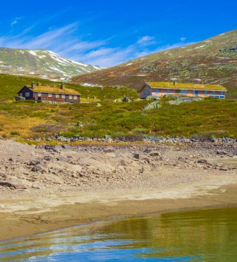 Muhteşem Vavatn Gölü manzarası engebeli kır evleri ve yaz boyunca Norveç 'in Hemsedal bölgesinde karlı dağlar.