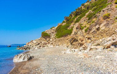 Yunanistan 'ın Kos Adası' ndaki doğal kıyı manzaraları, dağlık uçurumlar, kayalar, mavi plajlar ve dalgalar..