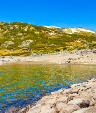 Vavatn Gölü manzarası inanılmaz engebeli kaya ve dağları Hemsedal Norveç 'te yaz boyunca karla kaplı.