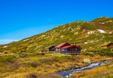 Amazing Vavatn landscape panorama view cottages and mountains with snow during summer in Hemsedal Norway.