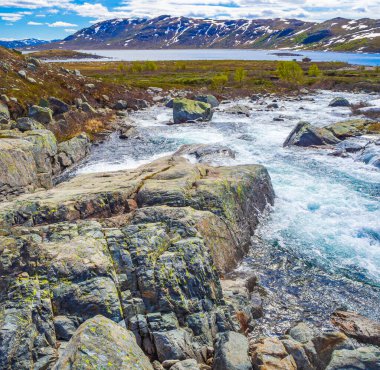 Vavatn gölünün kıyısındaki güzel Storebottane nehri Hemsedal Norveç 'in yaz manzarasında karla kaplı..