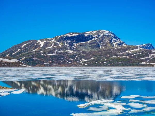 氷結したターコイズブルーの湖ヘムゼダルノルウェーの夏の風景と雪の山の中でVavatパノラマ — ストック写真