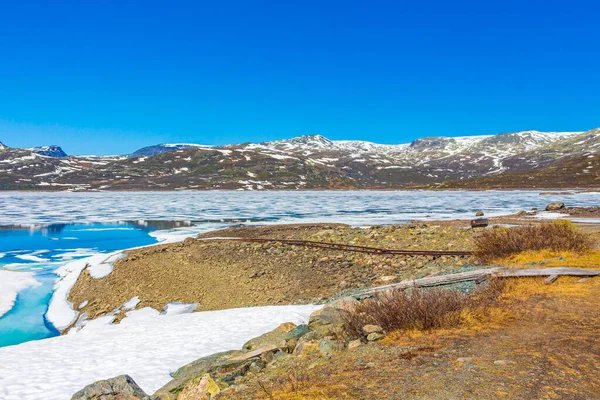 夏天的风景是冰冻的绿松石湖Vavatn全景 而在挪威赫赛达尔则是冰雪覆盖的群山 — 图库照片