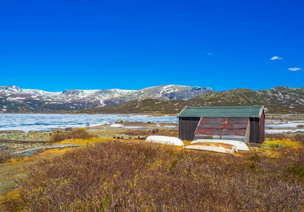 夏景下的Vavatn全景绿松石湖中的船和老房子 以及挪威赫赛达尔的雪山 — 图库照片