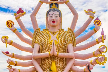 Koh Samui adası Surat Thani Tayland 'daki Wat Plai Laem tapınağındaki Tanrıça Guan Yin' in 18 kollu renkli heykeli..