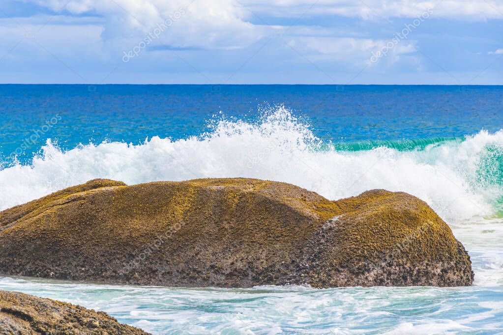 Strong wave hits huge rock at amazing Praia de Lopes Mendes beach on tropical island Ilha Grande in Angra dos Reis Rio de Janeiro Brazil.
