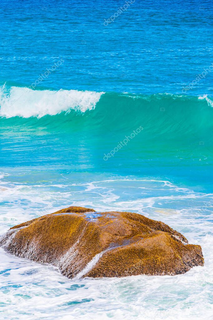 Strong wave hits huge rock at amazing Praia de Lopes Mendes beach on tropical island Ilha Grande in Angra dos Reis Rio de Janeiro Brazil.