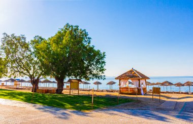 Yunanistan 'ın Kos Adası' ndaki bir tatil beldesinde sahil kenarındaki ağaçların arasında bir plaj masajı..