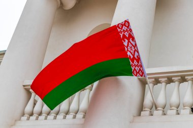 Beyaz arka planda Beyaz Rusya bayrağı olan bir binanın üzerinde Belarus bayrağı Minsk Belarus 'ta kırmızı beyaz yeşil.