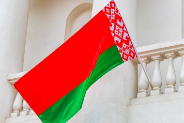 Beyaz arka planda Beyaz Rusya bayrağı olan bir binanın üzerinde Belarus bayrağı Minsk Belarus 'ta kırmızı beyaz yeşil.