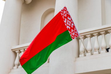Beyaz arka planda Beyaz Rusya bayrağı olan bir binanın üzerinde Belarus bayrağı Minsk Belarus 'ta kırmızı beyaz yeşil.