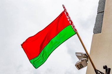Beyaz arka planda Beyaz Rusya bayrağı olan bir binanın üzerinde Belarus bayrağı Minsk Belarus 'ta kırmızı beyaz yeşil.