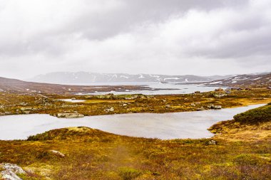 Vavatn Gölü manzarası inanılmaz engebeli kaya ve dağları Hemsedal Norveç 'te yaz boyunca karla kaplı.