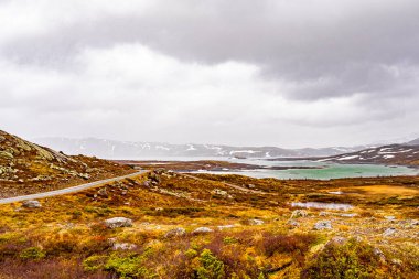 Vavatn Gölü manzarası inanılmaz engebeli kaya ve dağları Hemsedal Norveç 'te yaz boyunca karla kaplı.