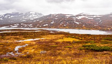 Vavatn Gölü manzarası inanılmaz engebeli kaya ve dağları Hemsedal Norveç 'te yaz boyunca karla kaplı.