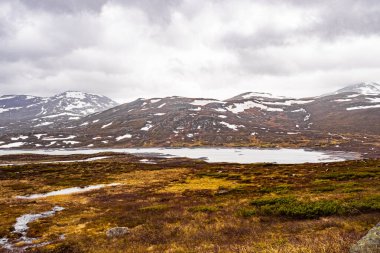 Vavatn Gölü manzarası inanılmaz engebeli kaya ve dağları Hemsedal Norveç 'te yaz boyunca karla kaplı.