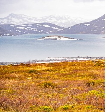 Vavatn Gölü manzarası inanılmaz engebeli kaya ve dağları Hemsedal Norveç 'te yaz boyunca karla kaplı.