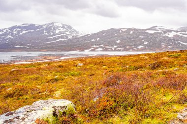 Vavatn Gölü manzarası inanılmaz engebeli kaya ve dağları Hemsedal Norveç 'te yaz boyunca karla kaplı.