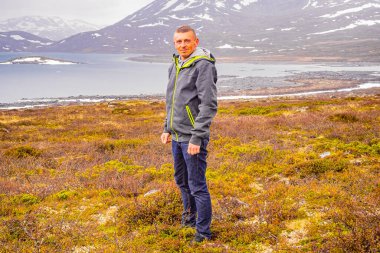 Vavatn Gölü 'nde gezgin turist engebeli manzara kayaları ve dağları Hemsedal Norveç' te yaz boyunca karla kaplı.