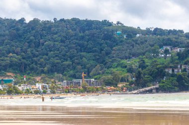 Kathu Phuket Thailand 08. October 2025 Patong Beach bay sea coast panorama view with promenade tourists people turquoise blue clear water waves and green mountains and palm trees in Patong Thailand.