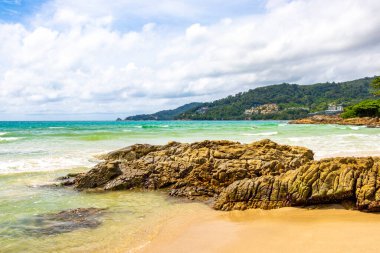 Patong Beach bay sea coast panorama view with turquoise blue clear water waves white sand and green mountains and palm trees in Patong Beach Kathu District Phuket Island Province Southern Thailand.