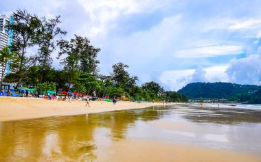Kathu Phuket Thailand 08. October 2025 Patong Beach bay sea coast panorama view with promenade tourists people turquoise blue clear water waves and green mountains and palm trees in Patong Thailand.