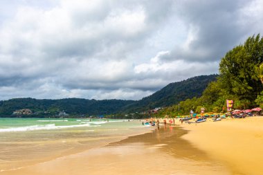 Kathu Phuket Thailand 08. October 2025 Patong Beach bay sea coast panorama view with promenade tourists people turquoise blue clear water waves and green mountains and palm trees in Patong Thailand.