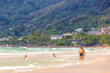 Kathu Phuket Thailand 08. October 2025 Patong Beach bay sea coast panorama view with promenade tourists people turquoise blue clear water waves and green mountains and palm trees in Patong Thailand.
