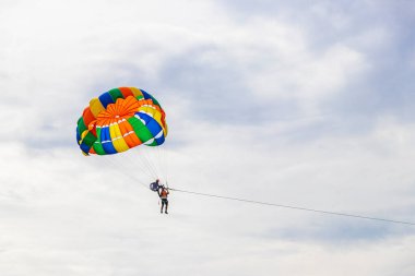 Kathu Phuket Thailand 10. October 2025 Patong Beach bay sea coast panorama view with people tourism and parasailing parachute sport activity water waves mountains and clouds in Patong Phuket Thailand.