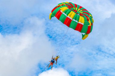Kathu Phuket Thailand 10. October 2025 Patong Beach bay sea coast panorama view with people tourism and parasailing parachute sport activity water waves mountains and clouds in Patong Phuket Thailand.