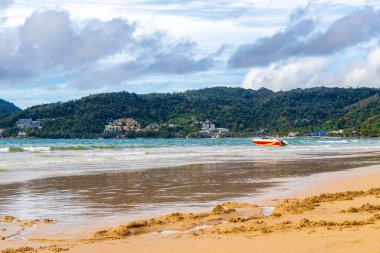 Kathu Phuket Tayland 10 numara. Ekim 2025 Patong Sahili sahil manzaralı gezinti turistleri açık mavi su dalgaları ve yeşil dağlar ve Patong Tayland 'daki palmiye ağaçları..