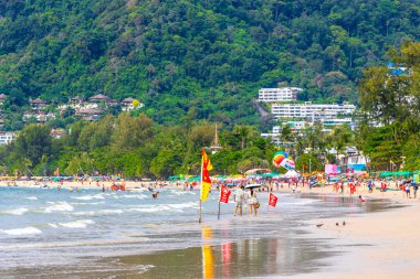 Kathu Phuket Tayland 10 numara. Ekim 2025 Patong Sahili sahil manzaralı gezinti turistleri açık mavi su dalgaları ve yeşil dağlar ve Patong Tayland 'daki palmiye ağaçları..