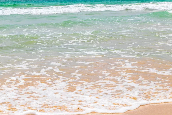 Waves turquoise blue water and sand at tropical beach and sea in Patong Beach Kathu District Phuket Island Province Southern Thailand in Southeast Asia.